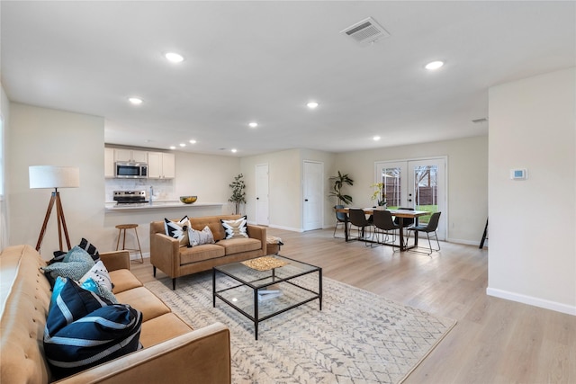 living room featuring light hardwood / wood-style flooring and french doors