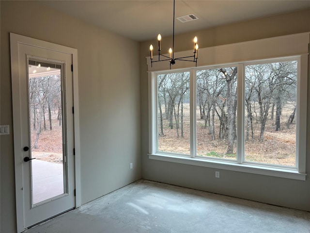 unfurnished dining area featuring a healthy amount of sunlight and a chandelier