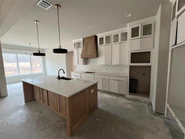 kitchen featuring sink, black electric cooktop, custom range hood, a large island, and white cabinets