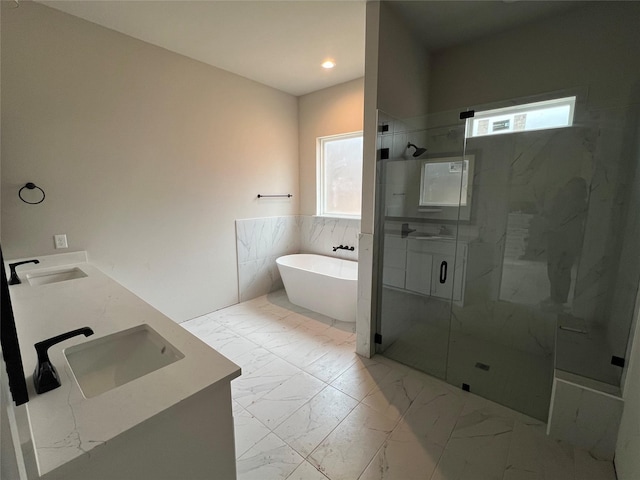 bathroom with vanity, a wealth of natural light, plus walk in shower, and tile walls