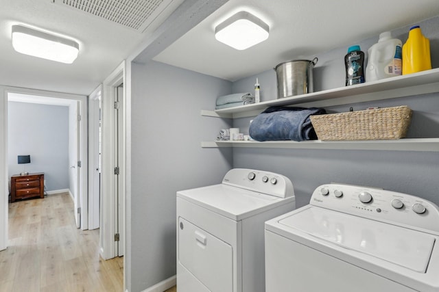 washroom featuring washer and clothes dryer and light wood-type flooring