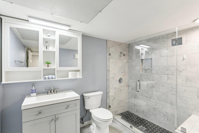 bathroom featuring a shower with door, vanity, and toilet