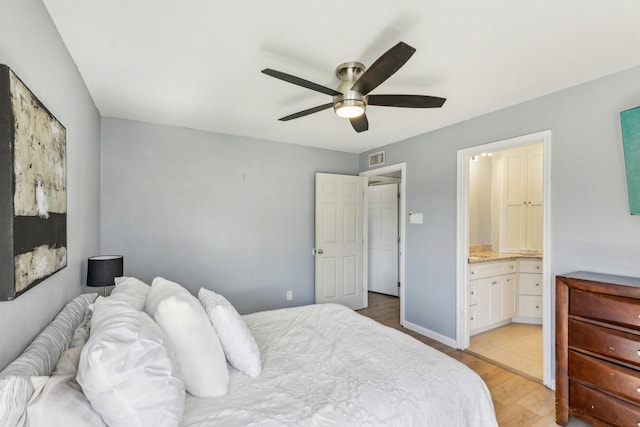 bedroom featuring ceiling fan, ensuite bathroom, and light wood-type flooring