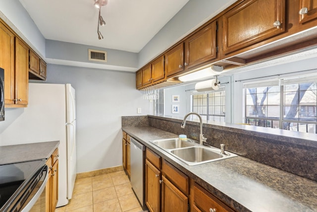 kitchen with light tile patterned flooring, stainless steel dishwasher, and sink