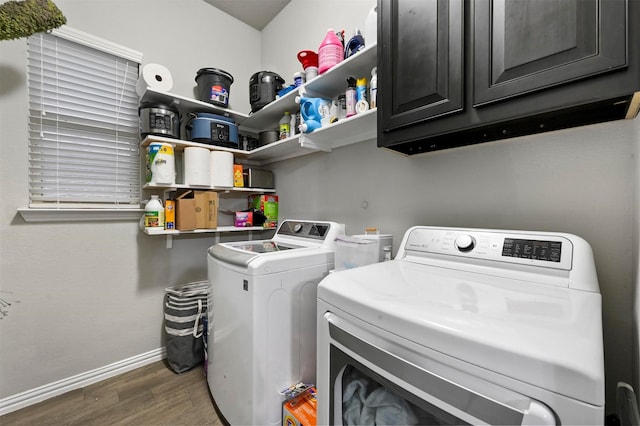 laundry room with dark hardwood / wood-style flooring, cabinets, and washer and dryer