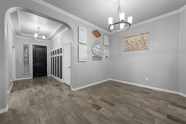 entrance foyer with crown molding, dark hardwood / wood-style floors, and a chandelier