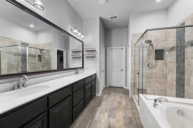 bathroom with vanity, wood-type flooring, and plus walk in shower