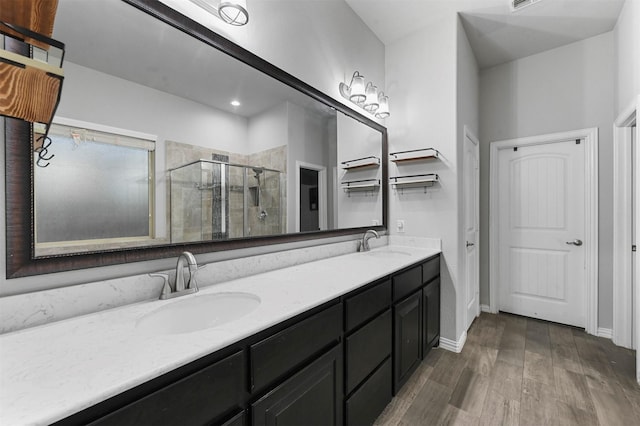 bathroom featuring wood-type flooring, a shower with shower door, and vanity