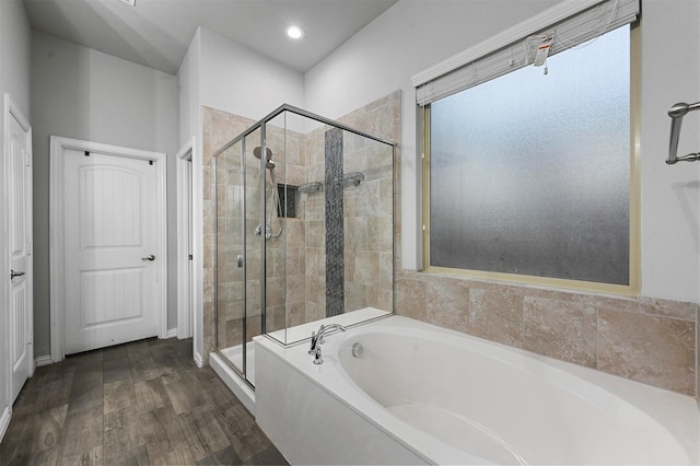 bathroom featuring plus walk in shower and hardwood / wood-style floors