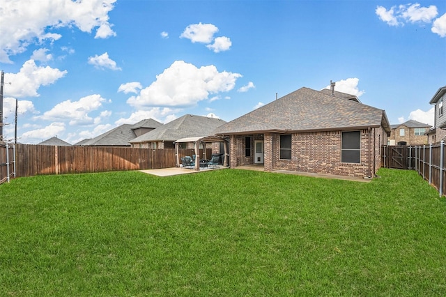 back of house with a patio and a yard