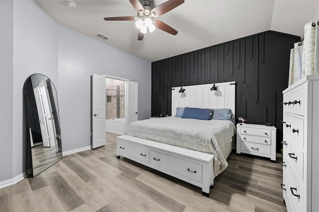 bedroom with connected bathroom, hardwood / wood-style floors, vaulted ceiling, and ceiling fan