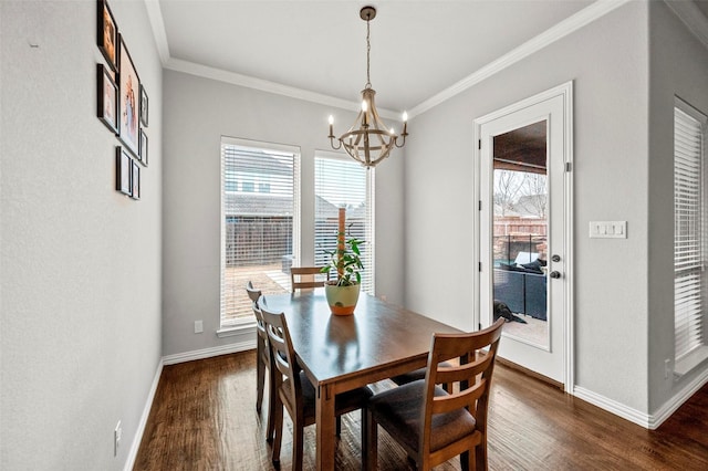 dining room with an inviting chandelier, a wealth of natural light, dark wood-type flooring, and ornamental molding