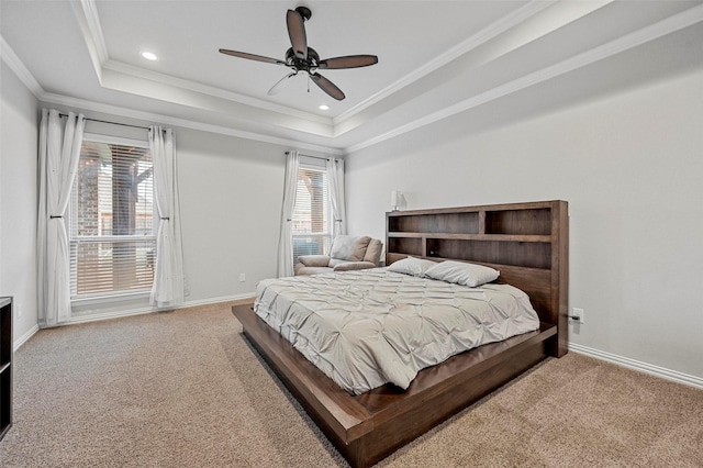 bedroom with crown molding, a tray ceiling, carpet floors, and ceiling fan