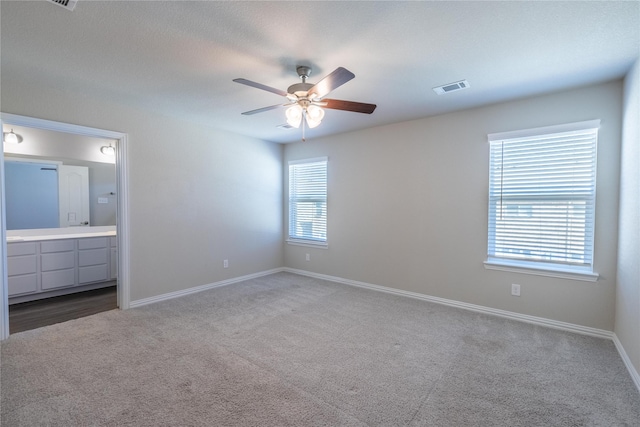 1267 Jones Trl, Lewisville, TX 75077 - unfurnished bedroom featuring carpet floors, baseboards, ensuite bathroom, and a ceiling fan