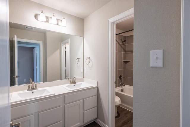 1267 Jones Trl, Lewisville, TX 75077 - bathroom with wood finished floors, toilet, double vanity, and washtub / shower combination