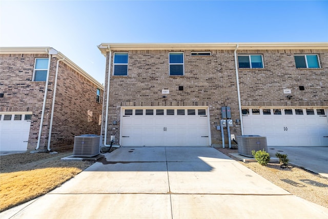 1267 Jones Trl, Lewisville, TX 75077 - view of front of property with central AC unit, an attached garage, driveway, and brick siding