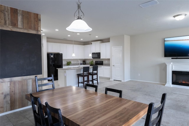 carpeted dining area with sink