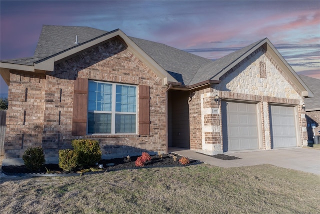 view of front of house featuring a garage and a lawn