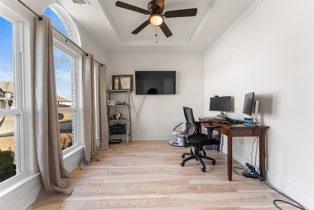 office area with ceiling fan, ornamental molding, a tray ceiling, and light wood-type flooring