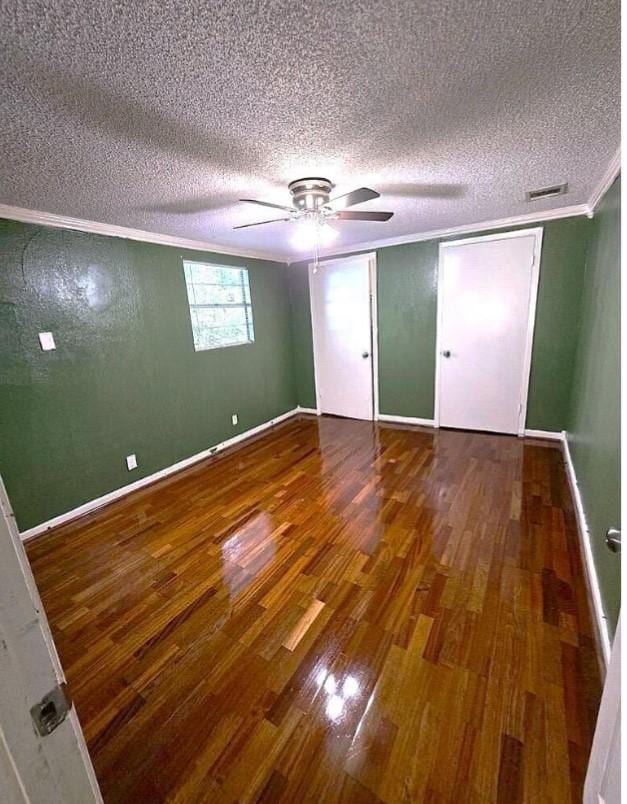 unfurnished bedroom with hardwood / wood-style flooring, ceiling fan, ornamental molding, and a textured ceiling