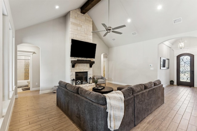 living room with wood tiled floor, a fireplace, arched walkways, and visible vents