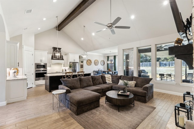 living area featuring visible vents, beamed ceiling, light wood-style floors, high vaulted ceiling, and ceiling fan with notable chandelier