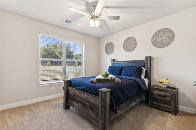 bedroom featuring baseboards, visible vents, a ceiling fan, and light colored carpet