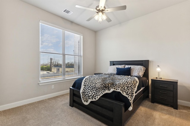 carpeted bedroom featuring ceiling fan, visible vents, and baseboards