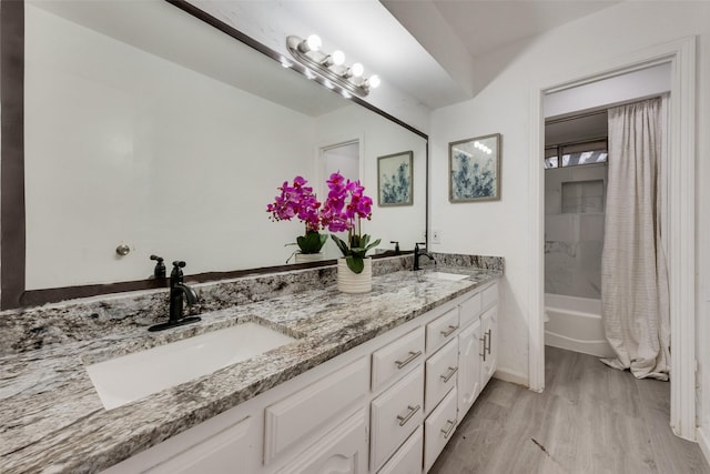 bathroom with hardwood / wood-style flooring, vanity, and shower / bath combo with shower curtain