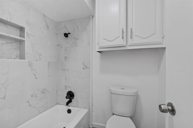 bathroom with tiled shower / bath combo and toilet