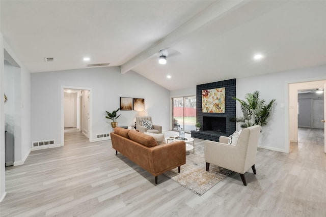 living room featuring lofted ceiling with beams, ceiling fan, light wood-type flooring, and a fireplace