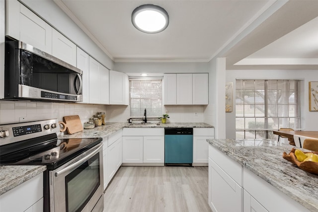 kitchen with sink, light hardwood / wood-style flooring, stainless steel appliances, light stone countertops, and white cabinets