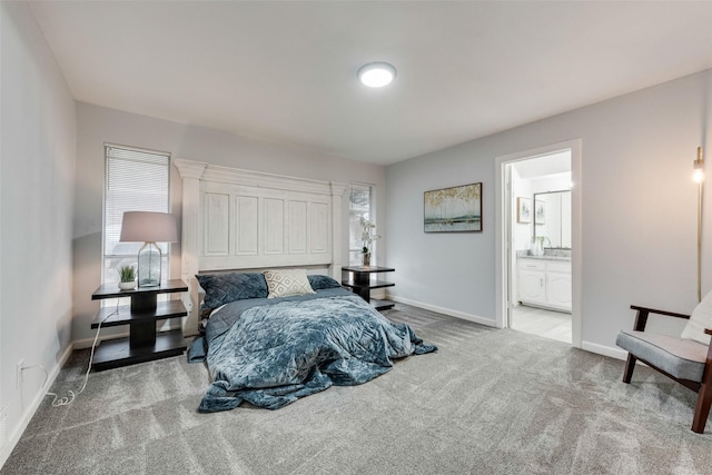 bedroom with light colored carpet, connected bathroom, and multiple windows