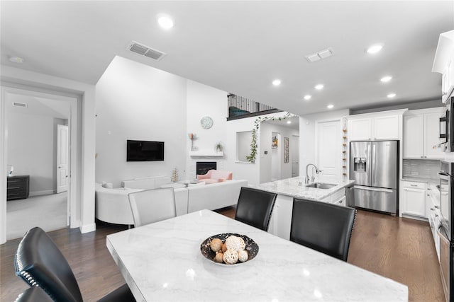 dining area featuring dark wood-style floors, a fireplace, visible vents, and recessed lighting