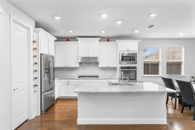 kitchen featuring visible vents, white cabinets, light stone counters, stainless steel appliances, and under cabinet range hood