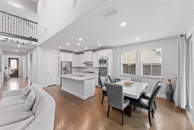 dining space featuring dark wood-type flooring, recessed lighting, visible vents, and baseboards