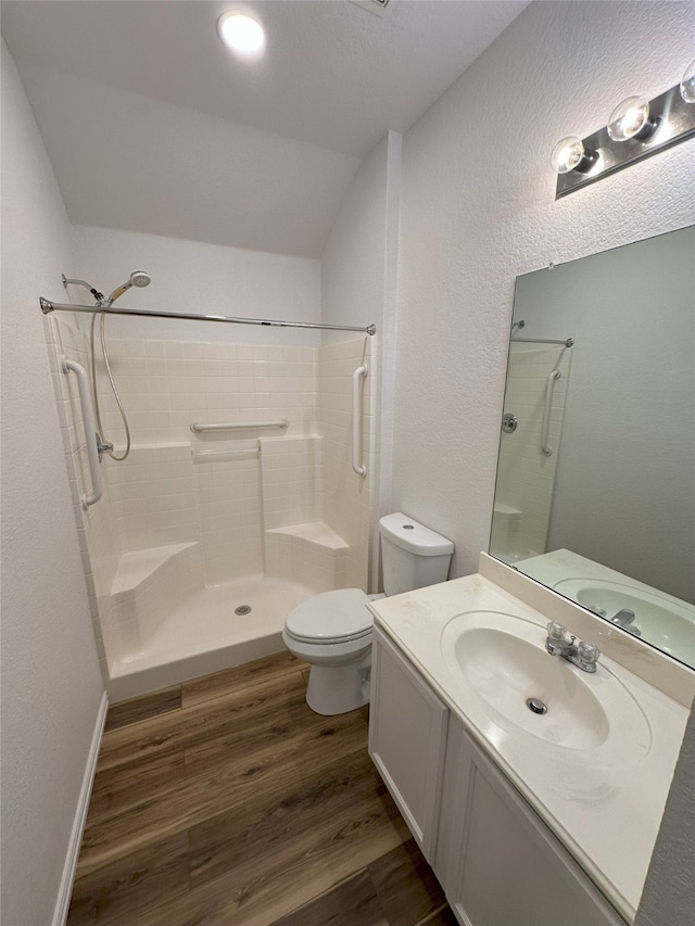 bathroom with vanity, toilet, hardwood / wood-style floors, and a shower