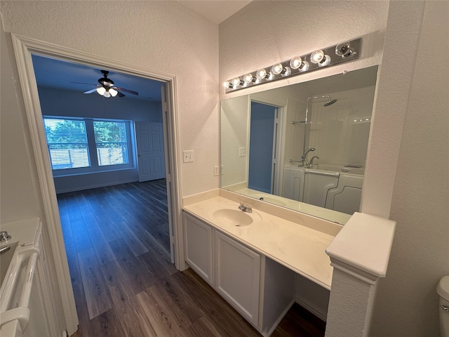 bathroom with toilet, a shower, vanity, ceiling fan, and hardwood / wood-style floors