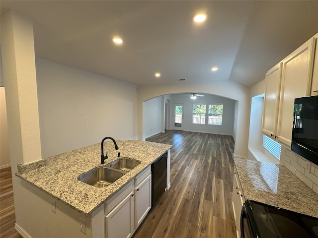 kitchen with an island with sink, sink, white cabinets, black appliances, and dark wood-type flooring