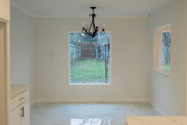 unfurnished dining area featuring ornamental molding and a notable chandelier