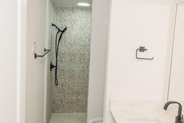 bathroom featuring vanity, toilet, and tiled shower