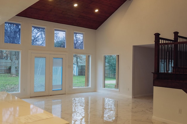 interior space with wood ceiling, a high ceiling, and a wealth of natural light