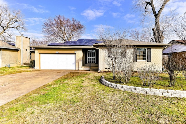 ranch-style home featuring a garage, a front yard, and solar panels