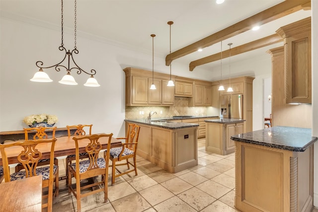 kitchen featuring hanging light fixtures, decorative backsplash, stainless steel fridge, and a kitchen island