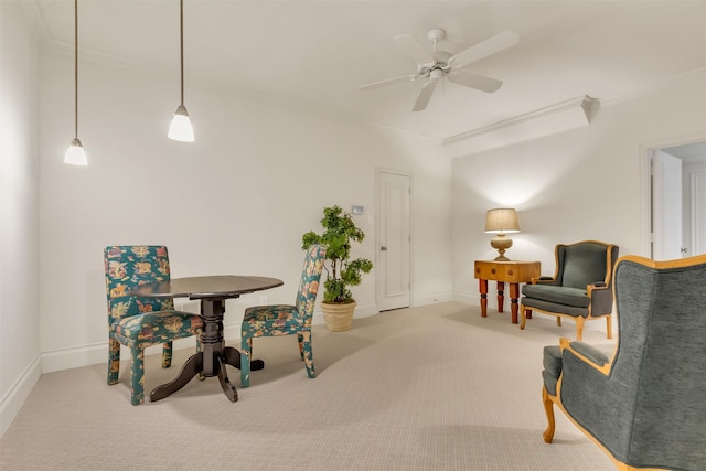 sitting room with crown molding, carpet floors, and ceiling fan