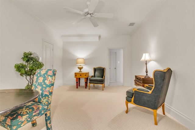 sitting room with ornamental molding, ceiling fan, and carpet