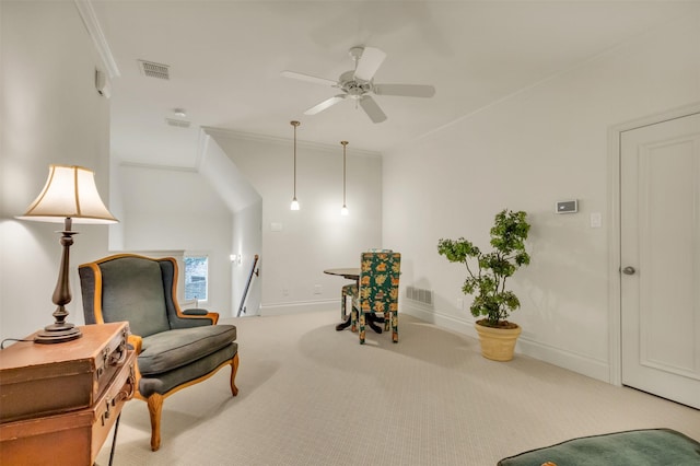 living area featuring ceiling fan, ornamental molding, and carpet flooring