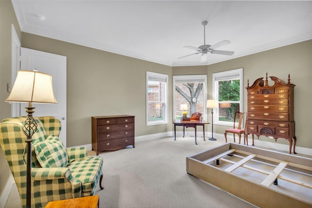 living area with ornamental molding, carpet flooring, and ceiling fan