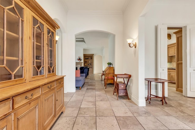 hallway with light tile patterned floors and ornamental molding