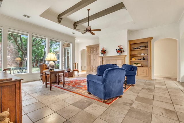 living room with ceiling fan, crown molding, built in features, and beamed ceiling